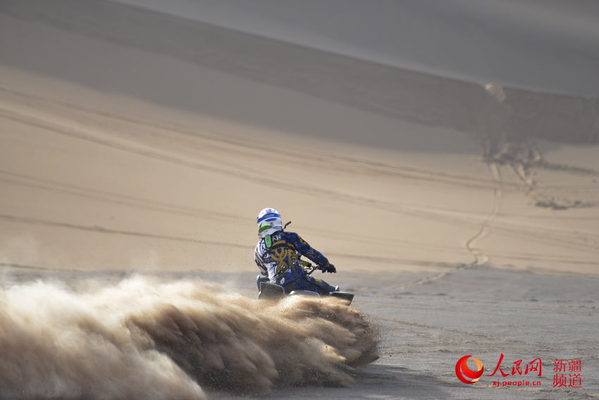 賽車高速駛過，飛馳的車輪卷起沙塵。徐蒙 攝